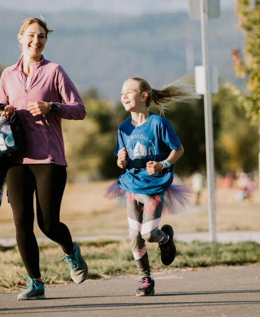 Young girl running with mentor