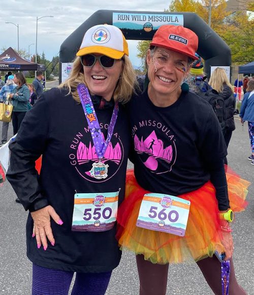 Fun picture of two people dressed up for a run with big smiles